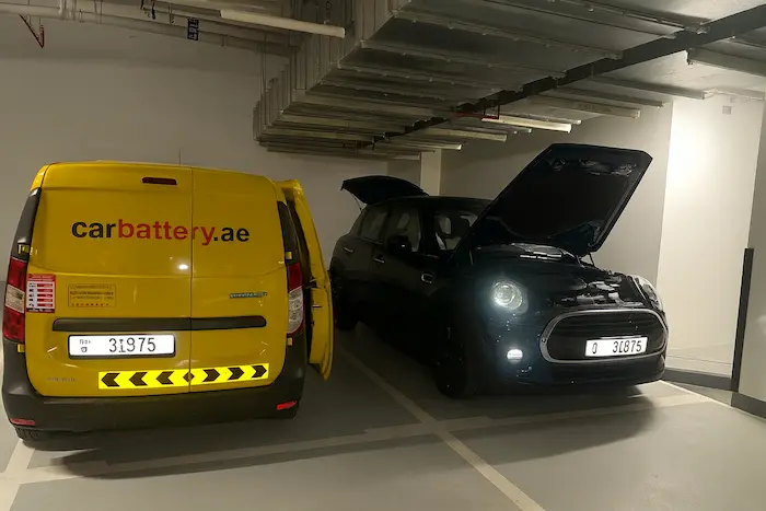 Mechanic inspecting a car battery for possible failure causes